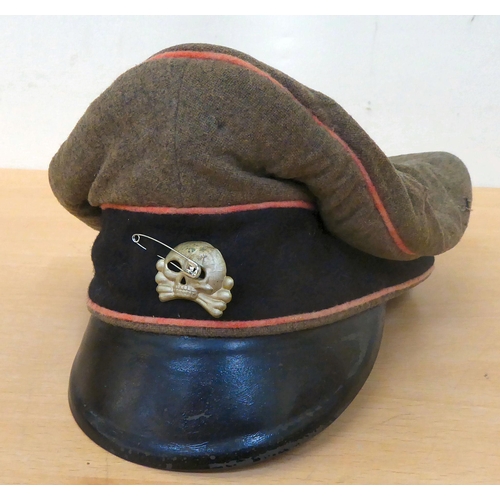 68 - A German SS khaki and black peaked cap with an emblem and orange piping(Please Note: this lot is sub... 