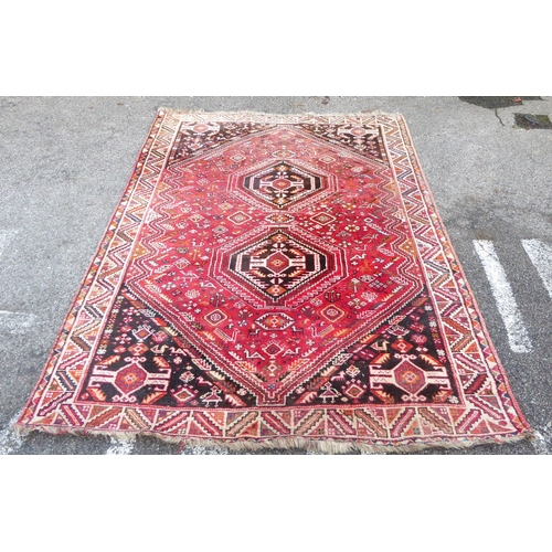 77 - A Ghashghai style Iranian rug, decorated with repeating stylised designs and zig-zag pattern border,... 