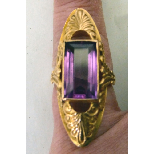 303 - A yellow metal ring (583), set with a synthetic purple stone