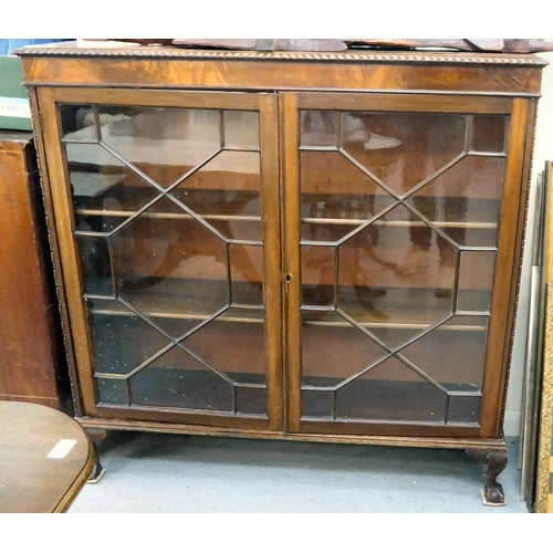 101 - A 1930s mahogany glazed bookcase with two shelves, raised on stubby cabriole legs  46