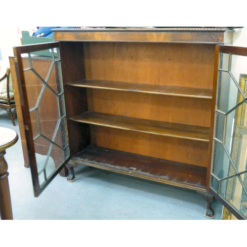 101 - A 1930s mahogany glazed bookcase with two shelves, raised on stubby cabriole legs  46