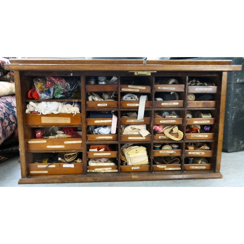 103 - An early 20thC oak chest with a rise-and-slide lockable front, enclosing a drawer interior  16