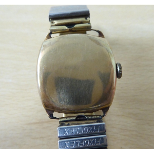 13 - A 9ct gold cased vintage wristwatch, faced by an Arabic dial, on a flexible gold plated, stainless s... 