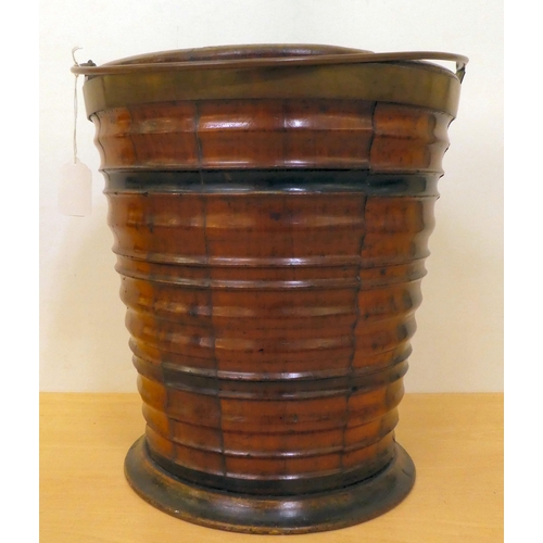 205 - A 19thC coopered wooden bucket of tapered, ribbed form with a brass collar and swing handle  12... 