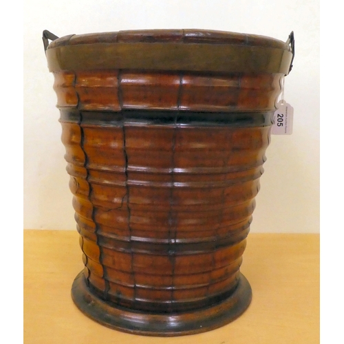 205 - A 19thC coopered wooden bucket of tapered, ribbed form with a brass collar and swing handle  12... 