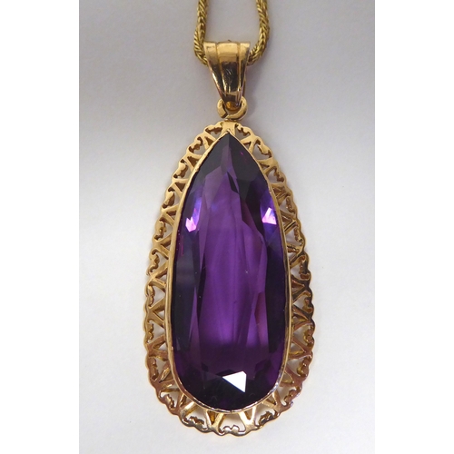 21 - A pear shaped, synthetic purple coloured stone pendant, on an 18ct gold twist link rope chain and ri... 