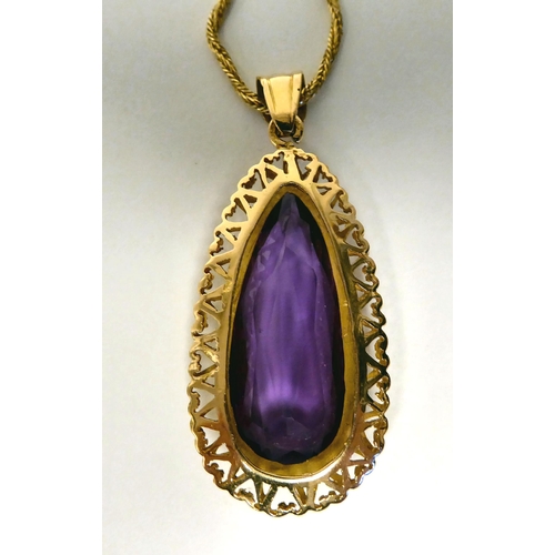 21 - A pear shaped, synthetic purple coloured stone pendant, on an 18ct gold twist link rope chain and ri... 