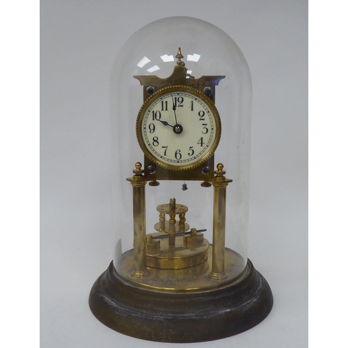 222 - An early 20thC lacquered brass cased torsion timepiece with an exposed movement, faced by a painted ... 