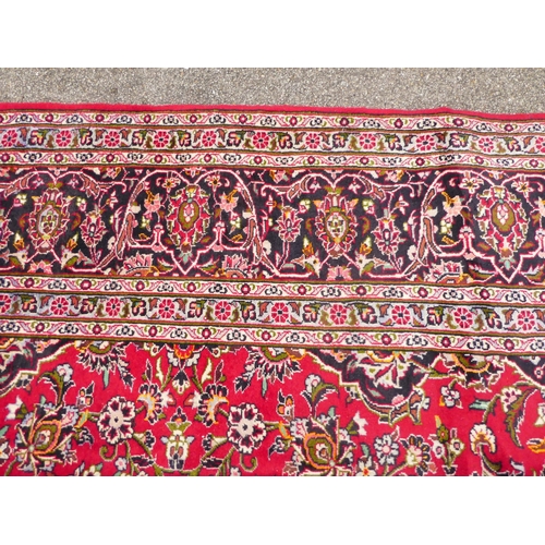 404 - A Persian Kashan design carpet, decorated with a central medallion, bordered by floral patterns, on ... 