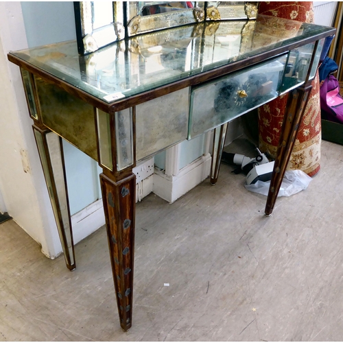 83 - A modern Venetian style partially mirrored dressing table with a central drawer, raised on square, t... 