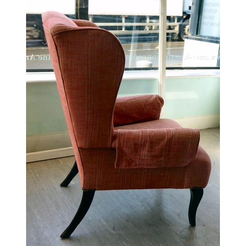 94 - A John Lewis wingback chair, upholstered in red fabric, raised on tapered forelegs