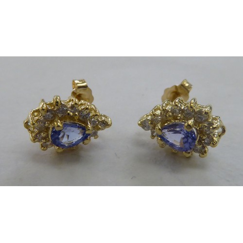 221 - A pair of 14ct gold, claw set, tanzanite and diamond earrings