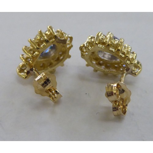 221 - A pair of 14ct gold, claw set, tanzanite and diamond earrings