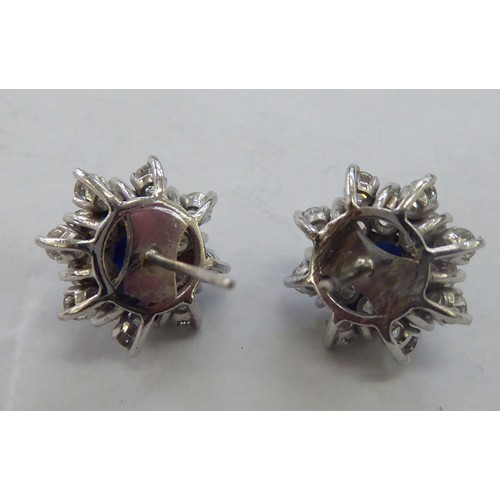 229 - A pair of 18ct white gold, sapphire and diamond cluster earrings