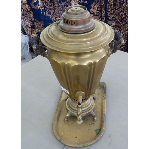 219 - A Russian brass samovar of tapered and panelled form with twin handles and a horizontal top, raised ... 