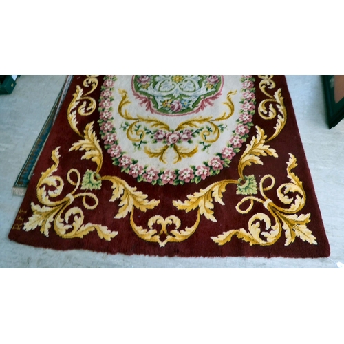 10 - A modern Spanish woollen rug, decorated with flora, on a red ground in pastel tones  80