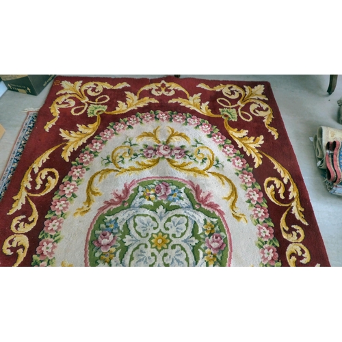 10 - A modern Spanish woollen rug, decorated with flora, on a red ground in pastel tones  80