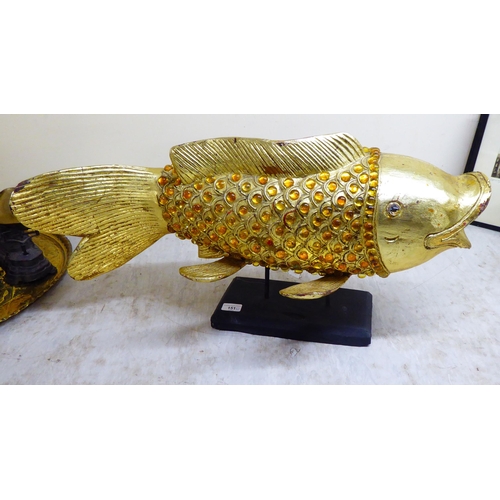 151 - A modern antique finished, gilt painted, carved wooden and amber coloured model carp, on stilts and ... 