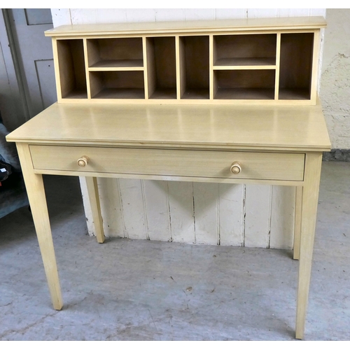 64 - A modern cream wash painted desk with a pigeonhole upstand, over a long drawer, raised on square, ta... 