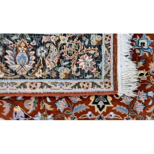 9 - A Persian rug, profusely decorated with floral designs, on a multi-coloured ground  56