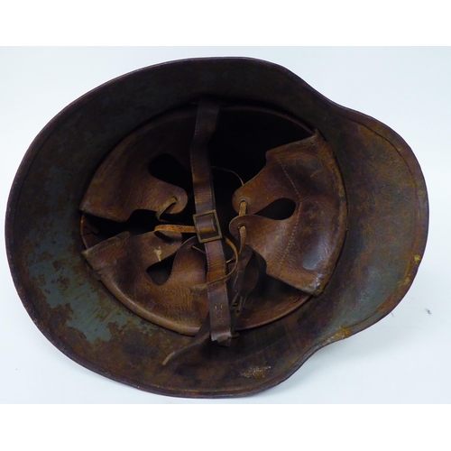 175 - A German World War I painted steel helmet with a hide liner and chinstrap(Please Note: this lot is s... 