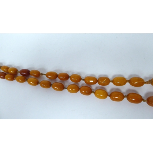 34 - A string of graduated, oval, amber coloured beads  30