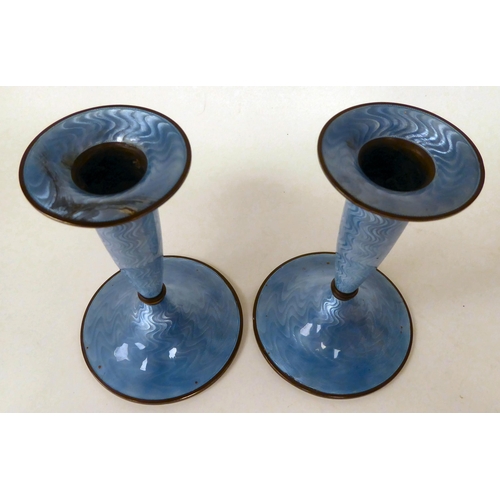 55 - A pair of Marius Hammer, Norwegian silver gilt and engine turned, powder blue enamel candlesticks wi... 