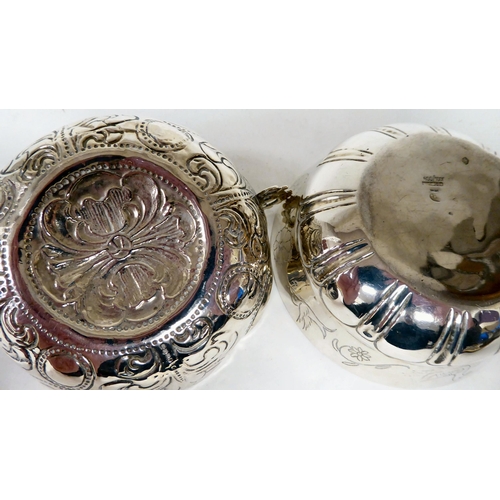 82 - A Mexican silver coloured metal bowl of lobed form, engraved with a frieze of flora and animals ... 