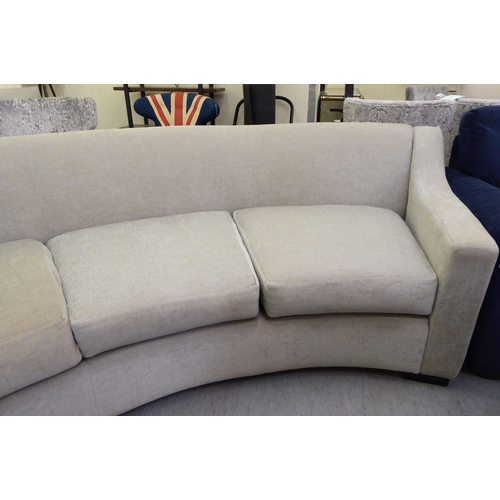 119 - A modern curved, three person settee, upholstered in a cream/Champagne coloured fabric  120