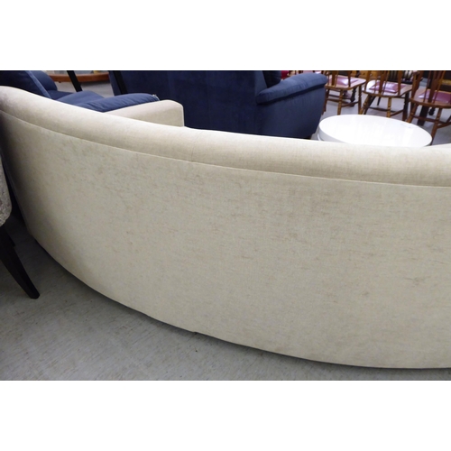 119 - A modern curved, three person settee, upholstered in a cream/Champagne coloured fabric  120