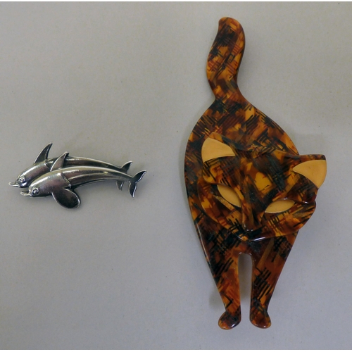 302 - A Lea Stein of Paris faux tortoiseshell effect brooch, fashioned as a cat; and another by Georg Jens... 