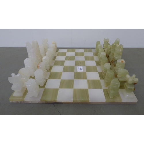 339 - A modern bi-coloured onyx chess set, on a 14