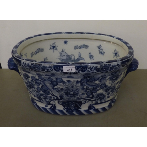 344 - A modern Chinese oval planter, decorated in blue and white with fish and traditional flora  10