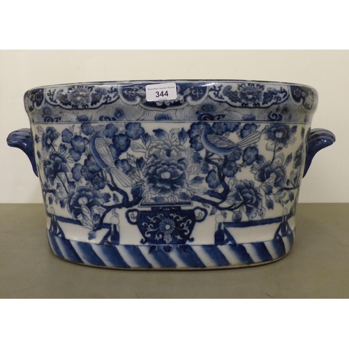 344 - A modern Chinese oval planter, decorated in blue and white with fish and traditional flora  10