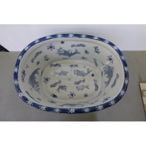 344 - A modern Chinese oval planter, decorated in blue and white with fish and traditional flora  10