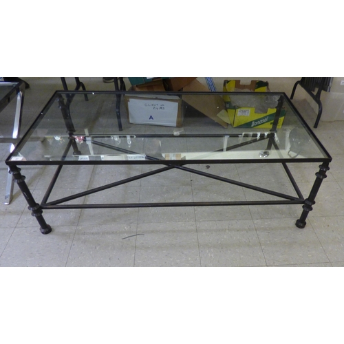 57 - A modern black painted, metal framed coffee table with a clear glass top  16