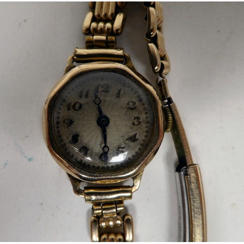 6 - A lady's 9ct gold cased wristwatch, faced by an Arabic dial, on a yellow metal strap