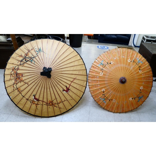 141 - Two 20thC Oriental handpainted paper parasols