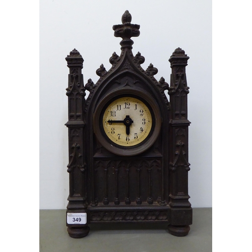 349 - An early 20thC cast iron Gothic Cathedral inspired, cased mantel timepiece; the modern movement face... 