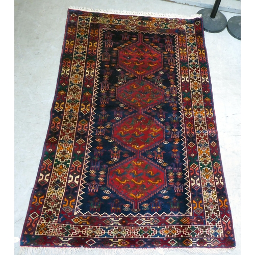 65 - A Kurdish style rug, decorated with four hexagonal motifs, on a multi-coloured ground  46