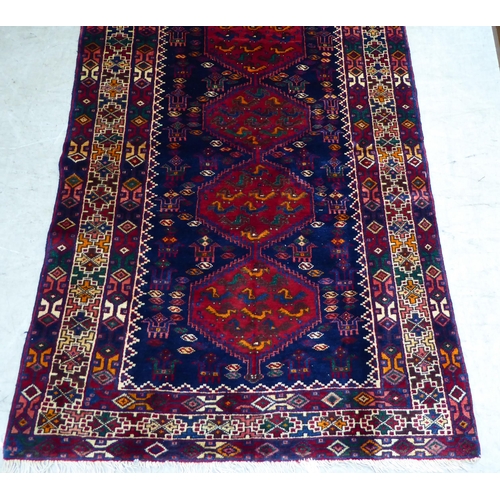 65 - A Kurdish style rug, decorated with four hexagonal motifs, on a multi-coloured ground  46