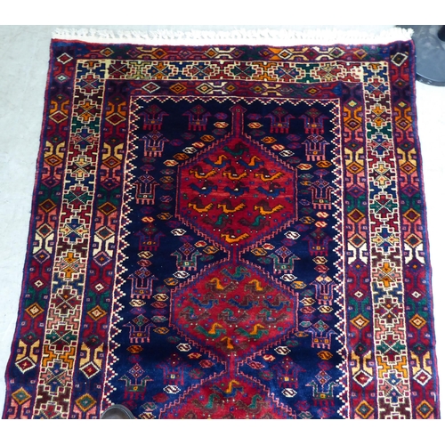 65 - A Kurdish style rug, decorated with four hexagonal motifs, on a multi-coloured ground  46