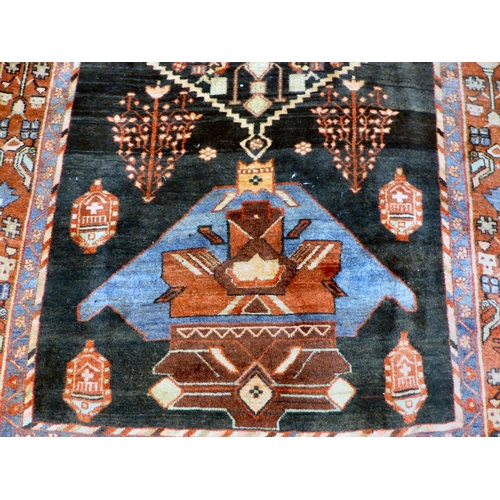 70 - A Hamadan design rug, decorated with geometric motifs and a central gul, on a black and red ground&n... 