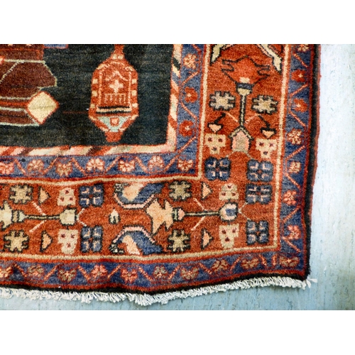 70 - A Hamadan design rug, decorated with geometric motifs and a central gul, on a black and red ground&n... 