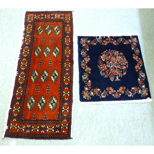 80 - Two Persian rugs, one decorated with floral designs, on a blue ground  24