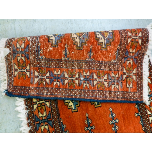 80 - Two Persian rugs, one decorated with floral designs, on a blue ground  24