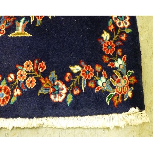 80 - Two Persian rugs, one decorated with floral designs, on a blue ground  24