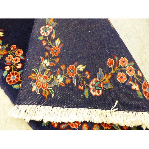 80 - Two Persian rugs, one decorated with floral designs, on a blue ground  24