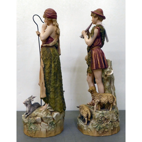 12 - Two Royal Dux figures, viz. a shepherd and shepherdess with sheep  each 15