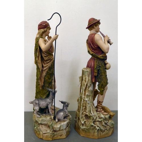 12 - Two Royal Dux figures, viz. a shepherd and shepherdess with sheep  each 15